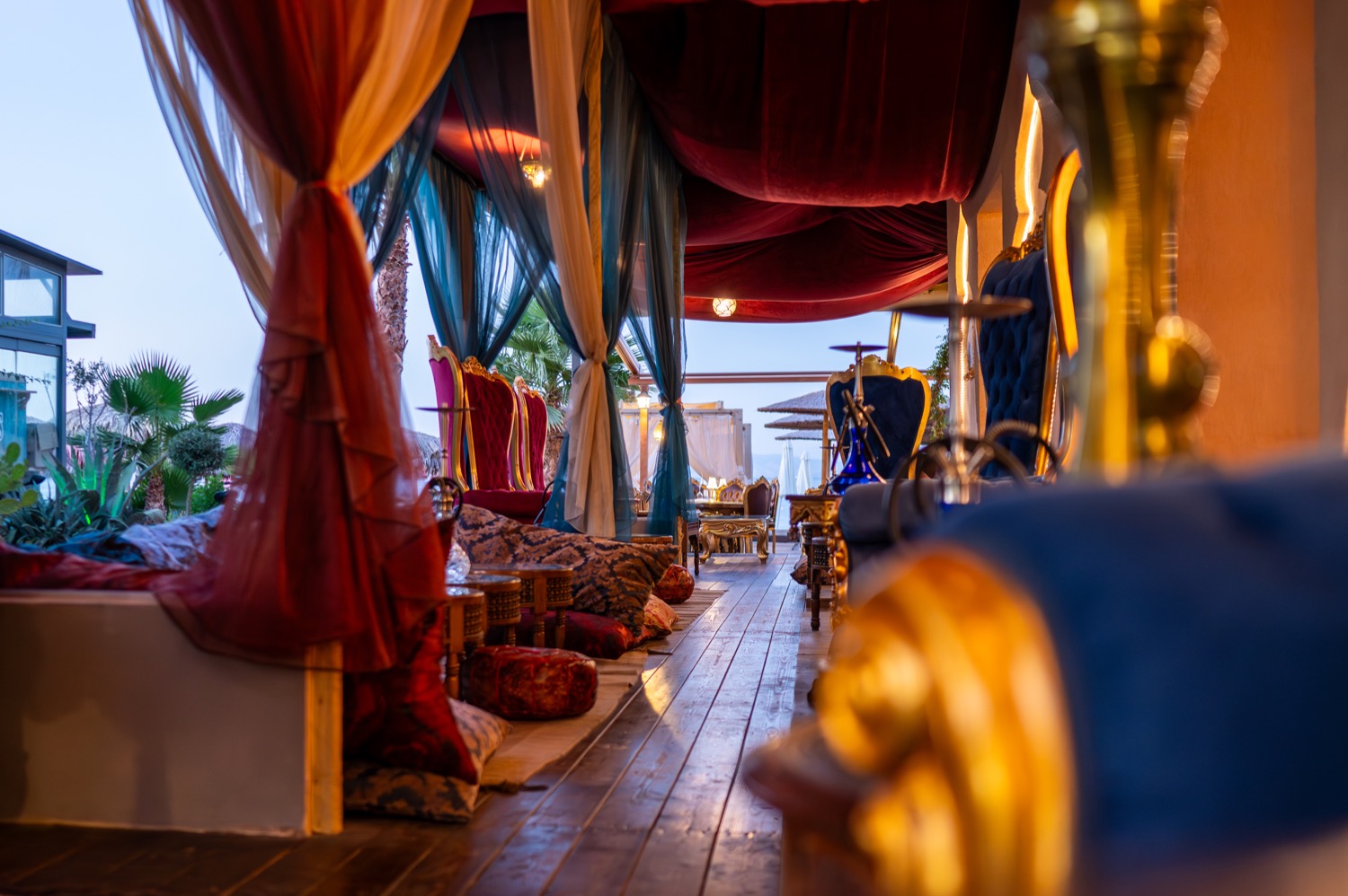 Harem interior walkway with curtains and blue-red chairs